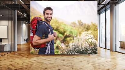 Hiking, happy and portrait of man on mountain for fitness, adventure and travel journey. Backpacking, summer and workout with male hiker trekking in nature path for training, freedom and explore Wall mural