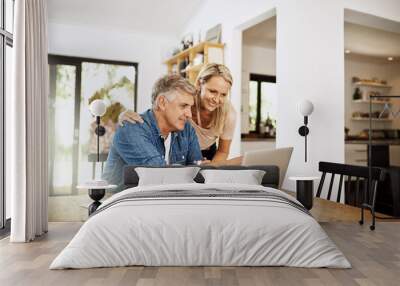 Couple with laptop planning finance, banking and checking retirement budget while becoming debt free at home. Smiling, happy and cheerful mature man showing woman an approved bank loan on technology Wall mural