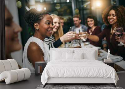 Everythings better when you do it with friends. Cropped shot of a group of young friends having a dinner party at a restaurant. Wall mural