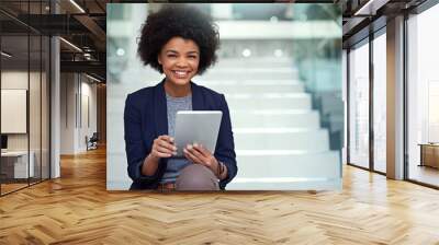 Its so easy to track my tasks online. Portrait of a young businesswoman using a digital tablet on the stairs in a modern office. Wall mural