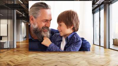 Smile, grandfather and boy with beard and playing, bonding and relax in living room. Happy family, play and fun with grandpa and pulling facial hair, embrace and caring cuddle with love in lounge Wall mural