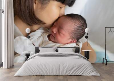 Asian mother kissing her newborn baby Wall mural