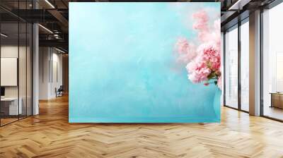  A blue table holds a blue vase filled with pink flowers Nearby, a painting depicts a sky-blue background Wall mural