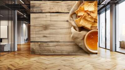   A bowl of tortilla chips beside a bag on a wooden table Wall mural