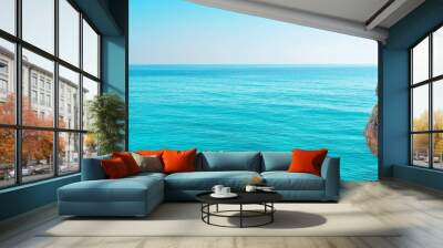  A cliffside view of the ocean with a blue sky backdrop Wall mural