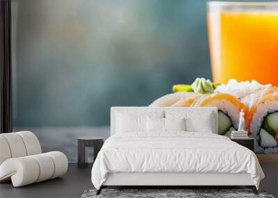  A plate of sushi next to two glasses of orange juice on a table Wall mural