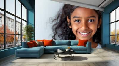  A tight shot of a child's smiling face framed by curly hair Wall mural