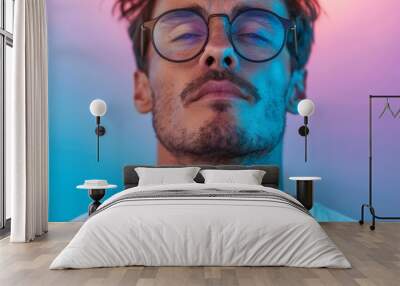  A tight shot of an individual in glasses, facing blue and pink lights behind a white T-shirt Wall mural