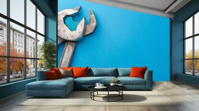  A tight shot of two pliers against a blue backdrop A wrench is positioned in the image's center Wall mural