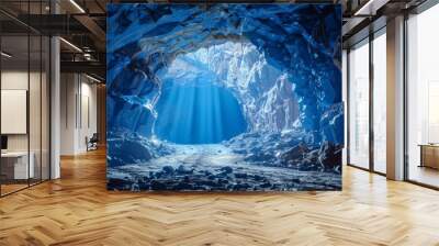   A tunnel in a cavern, sunlight streams through, ending at a beam of light emanating from the opening Wall mural