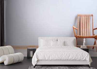  A white-walled room with hardwood flooring features two wooden chairs Wall mural