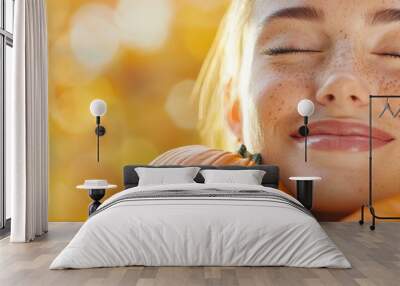  A woman with closed eyes holds pumpkins in front of her face Wall mural