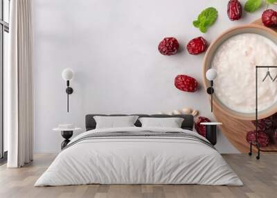  A wooden plate holds a white backdrop for a bowl of yogurt topped with raspberries and oatmeal Wall mural