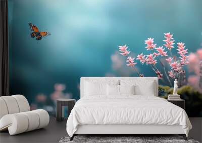  Butterfly hovering above a rock, pink flowers in close proximity, indistinct sky behind Wall mural