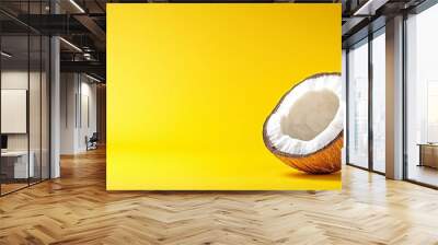  Two coconuts on a yellow background, one halved Wall mural