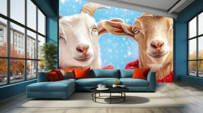  Two goats in red sweaters stand before a blue backdrop, adorned with snowflakes Wall mural