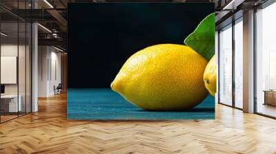  Two lemons stacked, one with a green leaf atop Wall mural