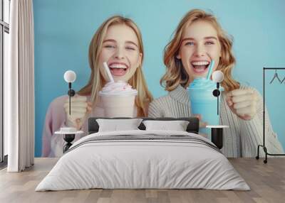  Two women, standing side by side, hold one cup of ice cream and another with milkshake Wall mural