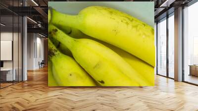 Bunch of bananas close-up. A bunch of yellow bananas on a white background Wall mural