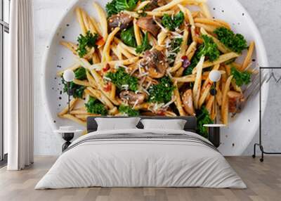 Whole grain pasta with kale, mushrooms, parmezan cheese in white plate on light background. Wall mural