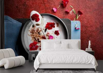 Yogurt bowl with homemade baked granola decorated with fresh Carnation edible flowers. Selective focus on spoon. Wall mural