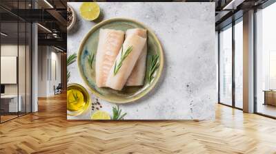 seafood background with ingredients for cooking. Raw cod loin fillet steak with aromatic herbs, spices, lime and olive oil on kitchen table. space for text Wall mural