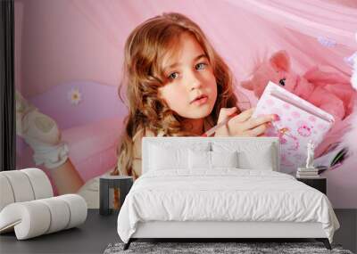 Beautiful little girl writing in her notebook Wall mural