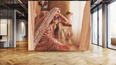 Beautiful pensive Indian bride with covered head sitting in a luxury vintage interior Wall mural