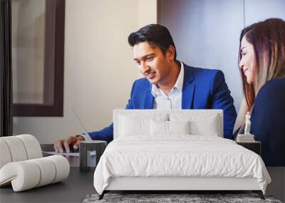 Handsome young Indian professional working on a laptop, training his colleague  Wall mural