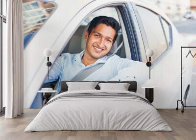 Young handsome Indian man proudly driving his own car Wall mural