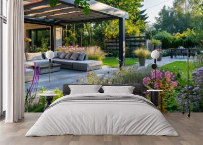 A beautiful garden with a patio area with a large umbrella and a couch Wall mural