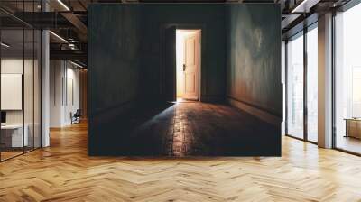 A dark hallway with a white door that is open. The light shining through the door creates a sense of hope and possibility Wall mural