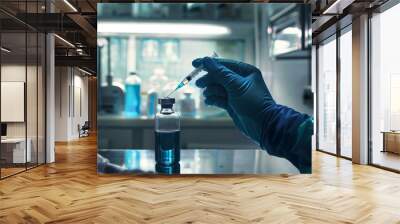 A person is holding a syringe and a blue bottle Wall mural