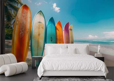 A row of surfboards are lined up on a beach Wall mural