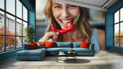 A woman is holding a red pepper and smiling Wall mural