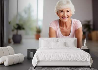 Doing yoga. Beautiful aged woman smiling and looking at camera while doing yoga Wall mural