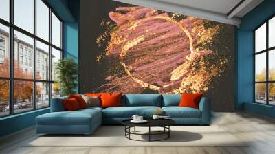 Glitter on abstract golden and pink watercolor stains, shiny round frame on black background Wall mural