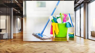 Bucket with cleaning items on blurry modern kitchen background. Washing brush and spray set with copy space. Wall mural