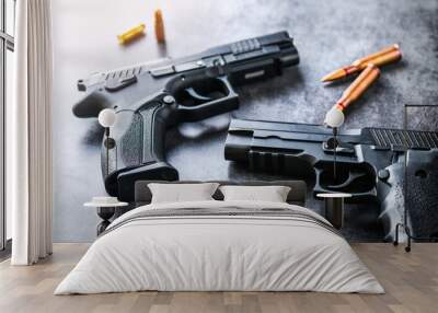 Hand guns on dark stone table top view. ammunition or bullets at black background. Wall mural