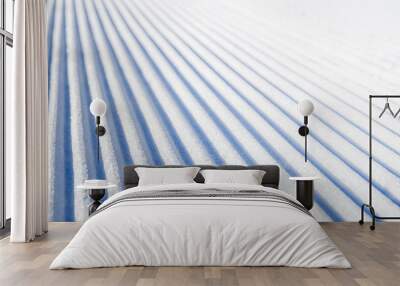 New groomed ski piste or slope. Lines in snow. Winter skiing background, fresh snow on slope. Wall mural