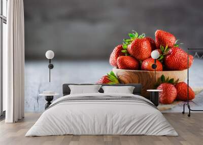 Nice fresh strawberries in wooden bowl. Juicy red forest fruits on table. Wall mural