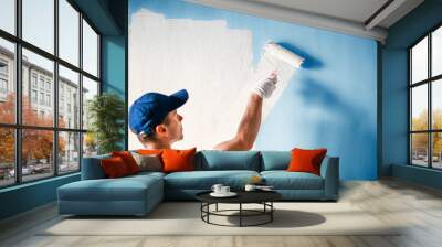 Painter painting a wall with paint roller. Wall mural