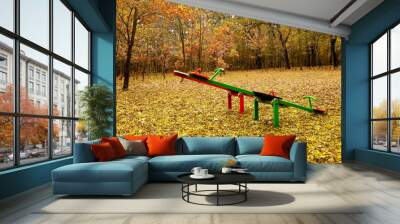 Playground in the park surrounded with forest. Autumn with beautiful colors. Cloudy rainy day. Wall mural