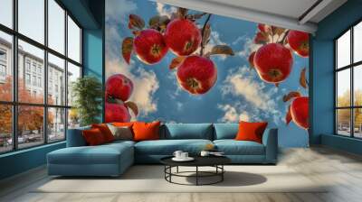 red apples on a tree with a backdrop of a clear blue sky and fluffy clouds, signifying fresh harvest. Wall mural