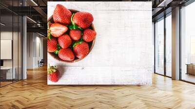 Ripe strawberries forest fruits in wooden bowl on white table. Fresh strawberry top view. Wall mural