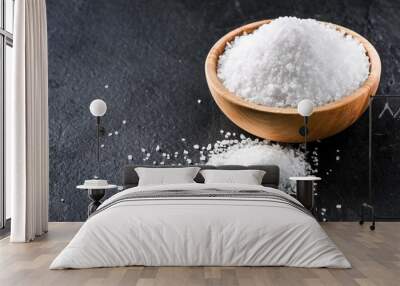 Salt in wooden olive bowl on stone table. Salt top view. Sea salt on black background. Wall mural