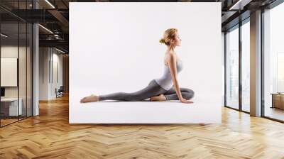 Pretty sporty blonde in doing yoga on white background Wall mural