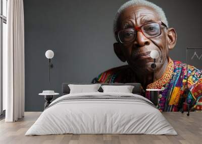 Portrait of a senior African American man wearing glasses and colorful traditional clothing looking directly at the camera. Wall mural