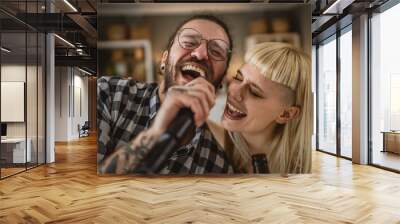 Adult couple caucasian sign karaoke on microphone at home Wall mural