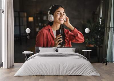 Adult woman with headphones listen to music and sing on mobile phone Wall mural